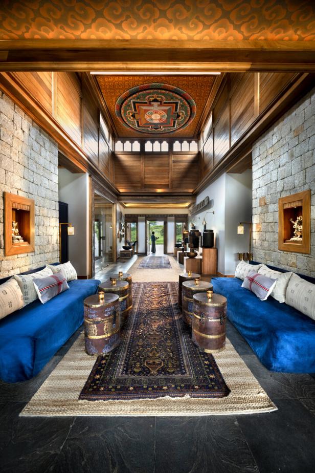Ein luxuriöser Hotellobby-Bereich mit blauen Sofas, verzierten Tischen und einem kunstvollen Deckengemälde.