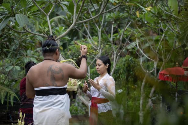 Ein Guru leitet die Wasserzeremonie Bali: Wo sich Touristen mit Feuer und Wasser spirituell reinigen
