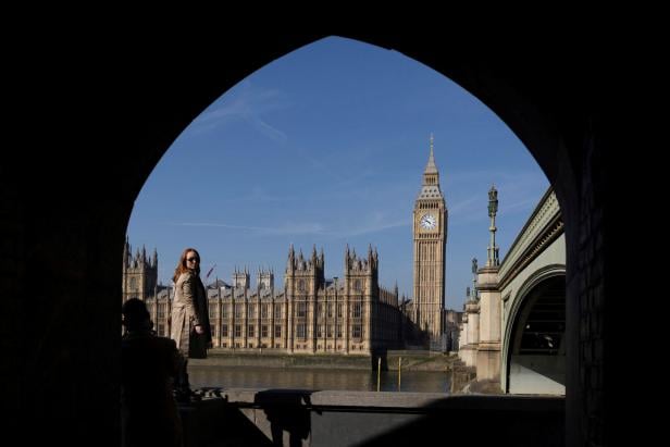 A woman is seen next to The Elizabeth Tower, commonly known as Big Ben in London Ausgerechnet England wünscht sich eine Reichensteuer
