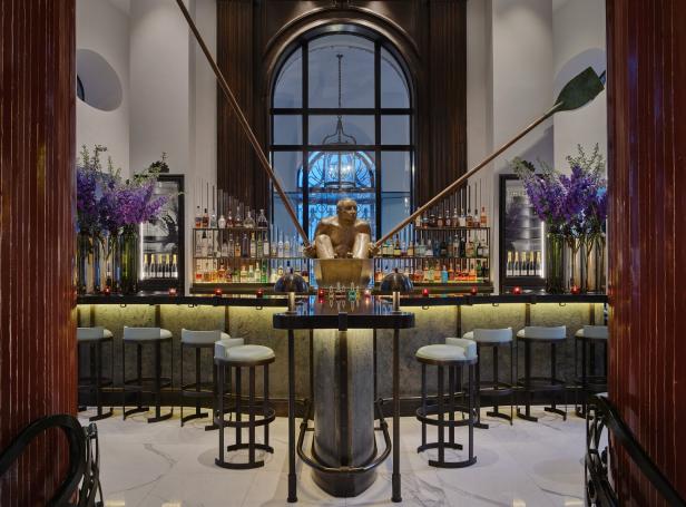 Eine Bar mit einer Statue eines Mannes in einem Boot und Regalen voller Flaschen im Hintergrund.
