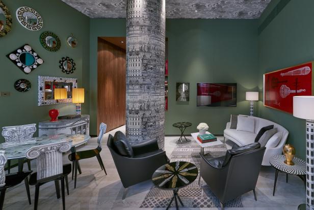Ein Wohnzimmer mit grünen Wänden, dekoriert mit Mustern und Kunstwerken.