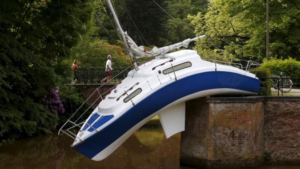 Ein blau-weißes Segelboot ist gegen eine Brücke gekracht.