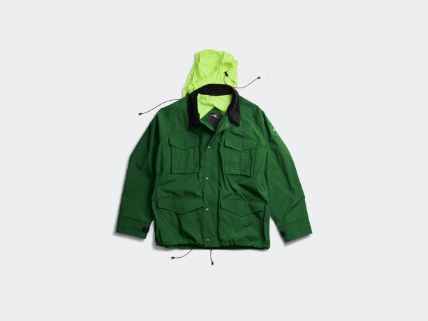 Eine grüne Jacke mit Kapuze liegt auf einem weißen Hintergrund.