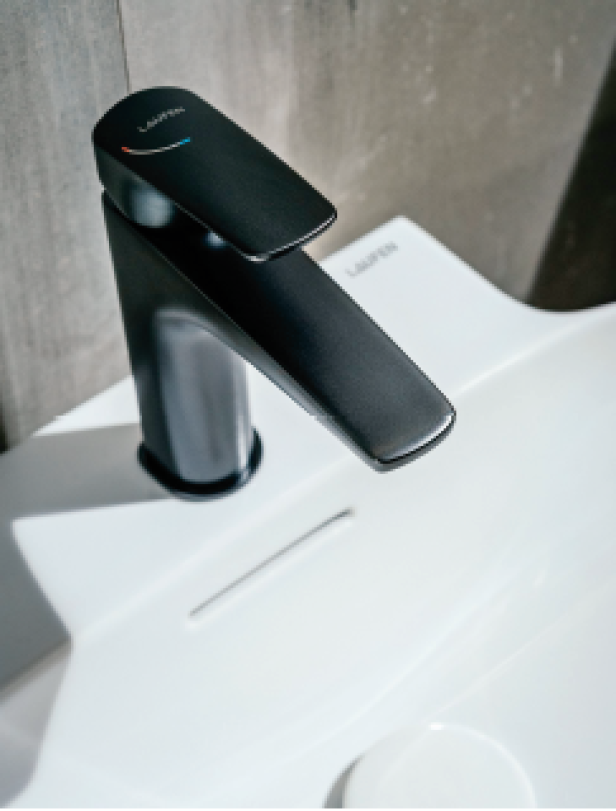 Ein schwarzer Wasserhahn der Marke Laufen auf einem weißen Waschbecken.