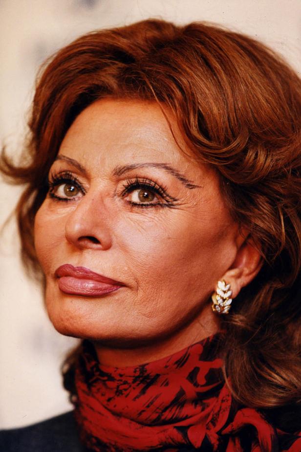 Porträt von Sophia Loren mit rotem Schal und goldenen Ohrringen.