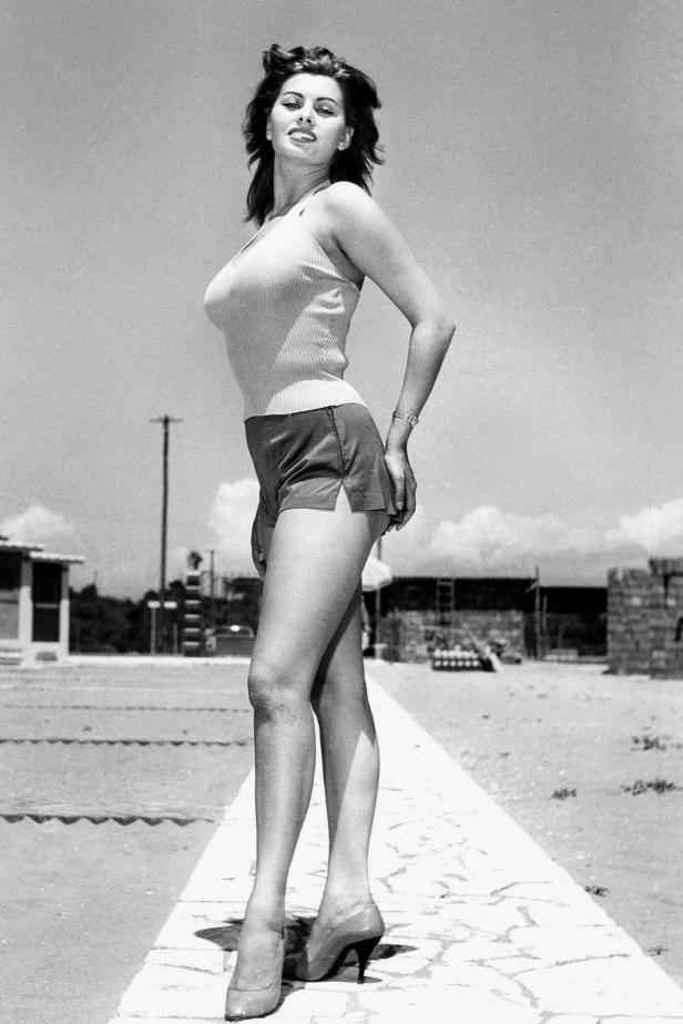 Schwarzweißporträt von Sophia Loren in Shorts und Top, stehend auf einem Weg.