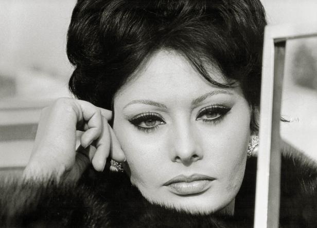 Schwarzweißporträt von Sophia Loren mit Pelzmantel und auffälligem Make-up.