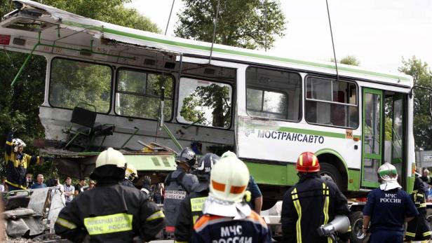 Ein beschädigter Bus wird von Rettungskräften und Feuerwehrleuten untersucht.