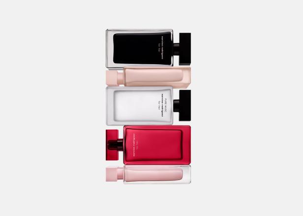 Mehrere Flakons „Narciso Rodriguez for her“-Parfüm in verschiedenen Farben liegen übereinander.