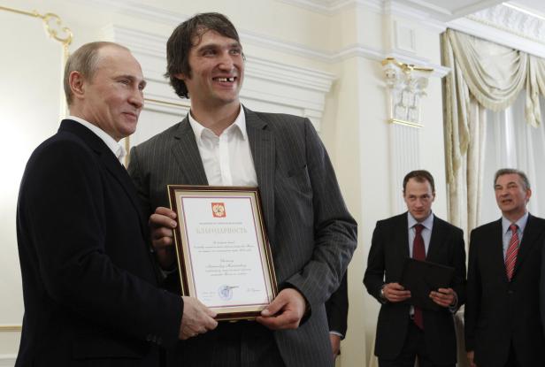 Russian President Vladimir Putin and Russian national ice hockey team member Alexander Ovechkin hold a certificate thanking Ovechkin for the great contribution into the team's victory at the Novo-Ogaryovo residence outside Moscow Alexander Owetschkin: 895 Tore, 165 Millionen Dollar und Gratulation von Putin