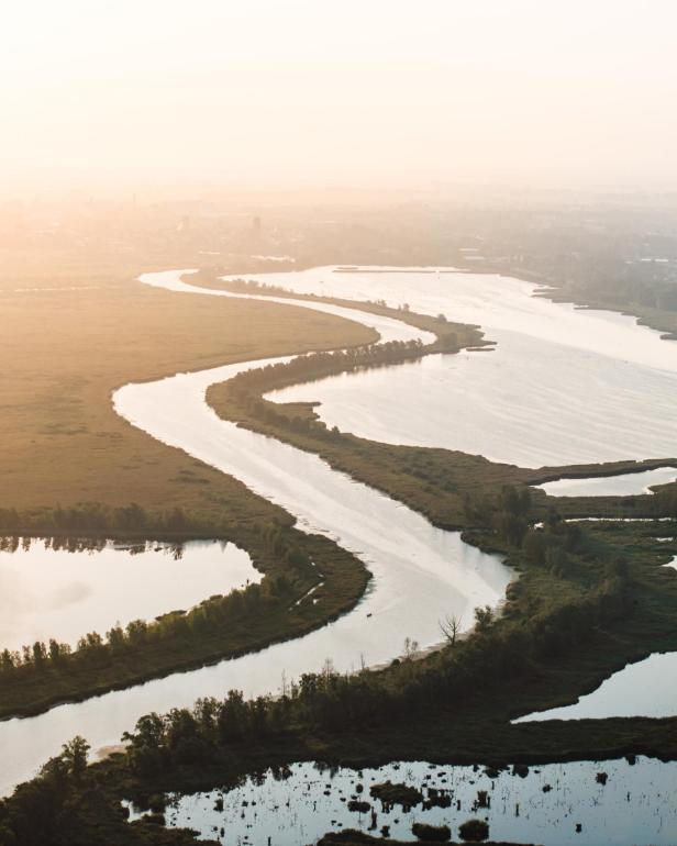 Ein wilder Fluss mit verschiedenen Nebenflüssen, im Sonnenuntergang.
