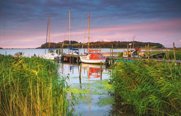 Ein Fischereihafen im Licht eines roten Sonnenuntergangs.