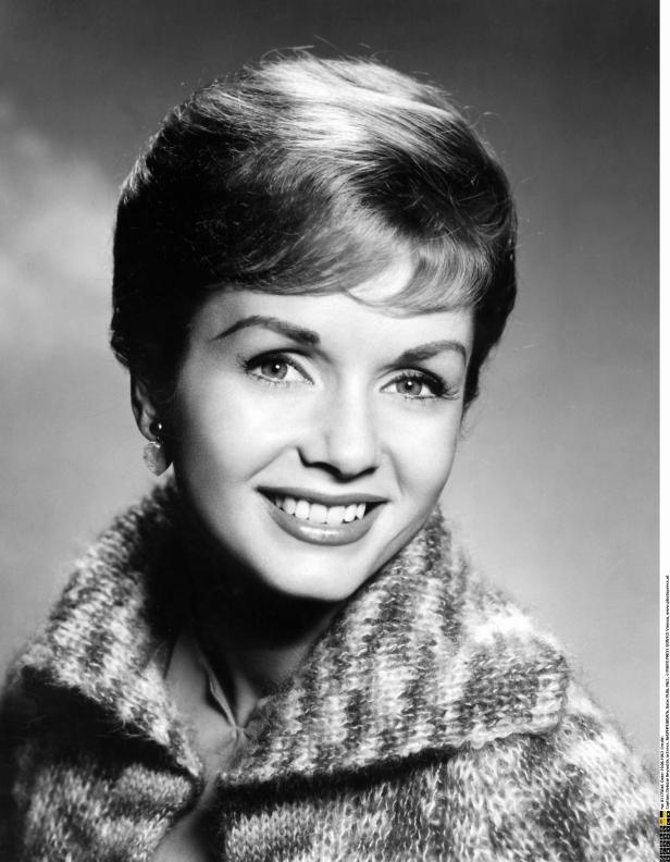 Ein Schwarzweißporträt der lächelnden Schauspielerin Debbie Reynolds.