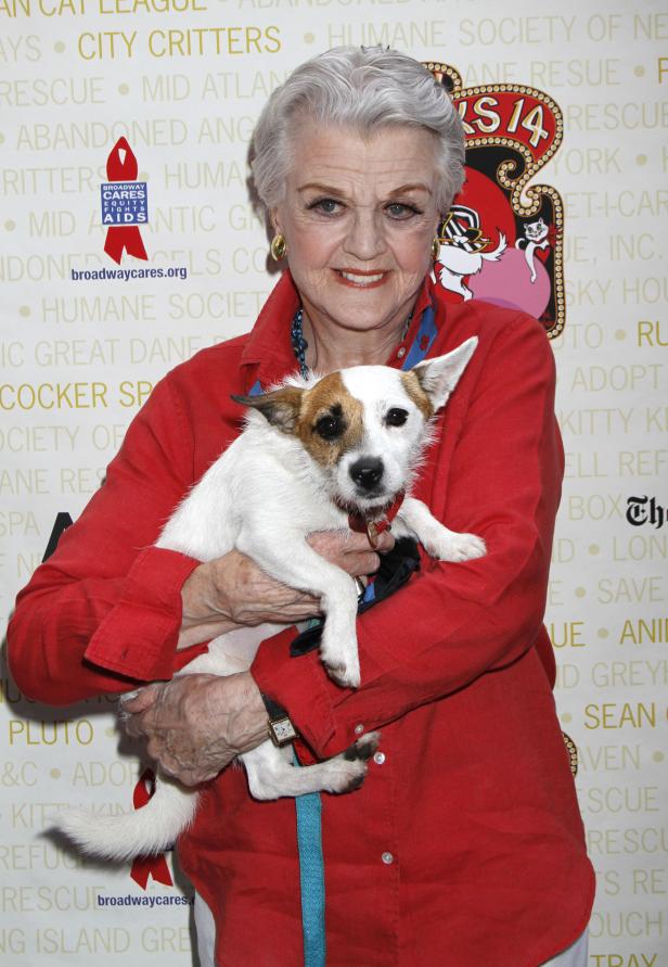 Angela Lansbury hält einen kleinen Hund im Arm.