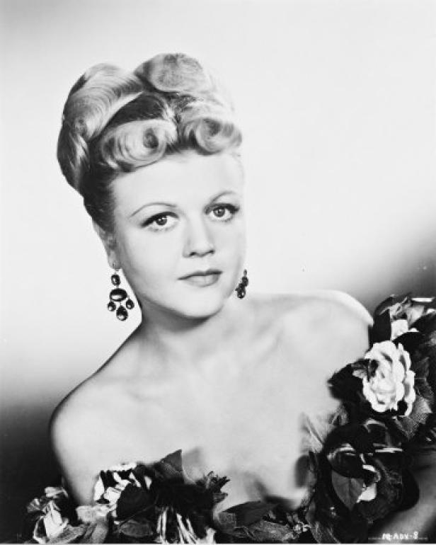Ein Schwarz-Weiß-Porträt von Angela Lansbury mit aufwendiger Frisur und Ohrringen.