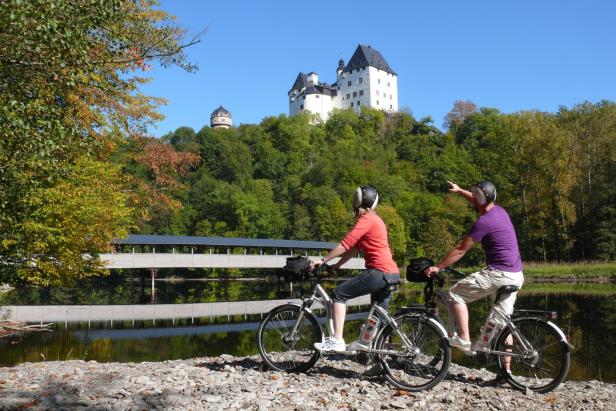 Ein Paar fährt gemeinsam auf Fahrrädern durch eine malerische Landschaft.