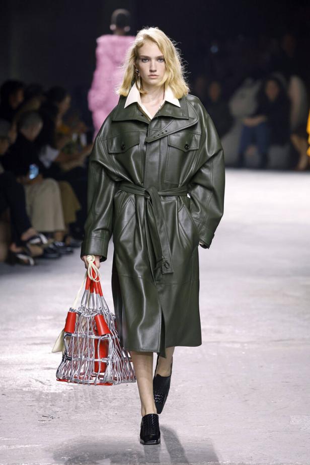 Eine Frau trägt einen olivgrünen Ledermantel von Bottega Veneta auf dem Laufsteg.