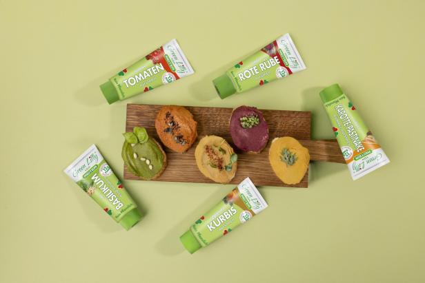 Verschiedene Sorten pflanzlicher Aufstriche von Green Lilly auf Brot und in Tuben präsentiert.