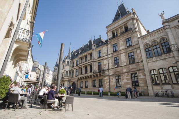 Menschen sitzen in einem Straßencafé in Luxemburg-Stadt.
