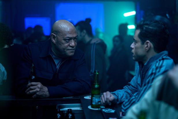 Laurence Fishburne und Rami Malek sitzen in einer Bar und unterhalten sich.