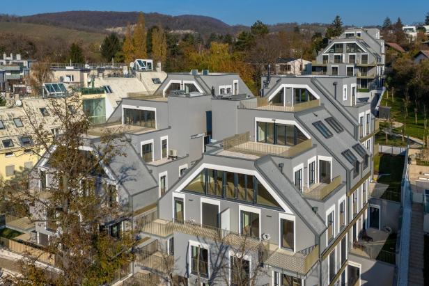 Mehrstöckiges modernes Wohngebäude mit eleganter Fassade und großzügigen Balkonen in einer urbanen Umgebung.