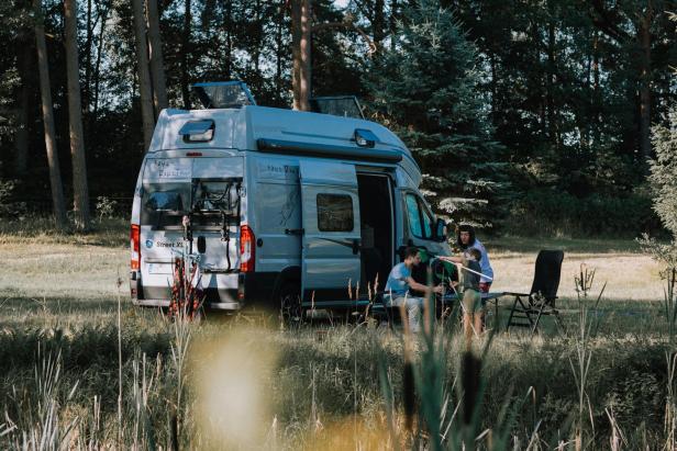 Eine Familie campt mit einem „Street XL“-Wohnmobil in der Lüneburger Heide.