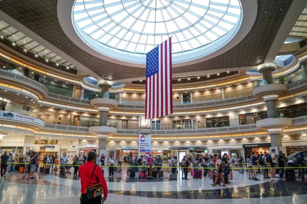 1. Atlanta Hartsfield-Jackson In einem belebten Flughafen hängt eine große amerikanische Flagge unter einer Glaskuppel.