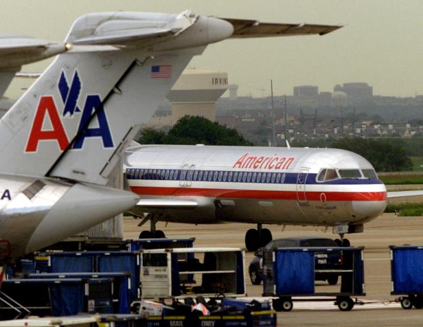 3. Dallas Fort Worth Ein Flugzeug der American Airlines auf einem Rollfeld mit Gepäckwagen im Vordergrund.