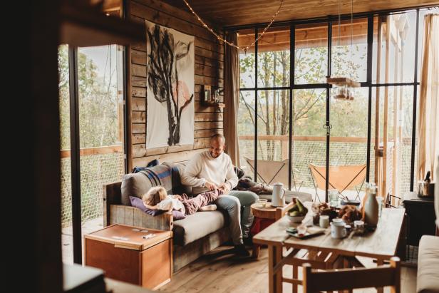 Ein Vater sitzt mit seiner Tochter in einem gemütlichen Ferienhaus in den Ardennen.