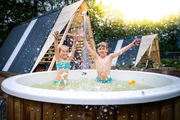 Zwei Kinder planschen in einem Badezuber auf dem Papillon Country Resort.