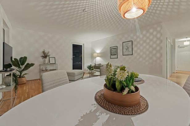 Ein Esstisch in einem weißen Wohnzimmer. 