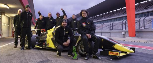 Simon Schranz und das Renauer-Motorsport-Team posieren mit einem Rennwagen.