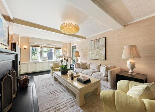 Ein Wohnzimmer mit einem Sofa, Sesseln und einem Couchtisch unter einem Kronleuchter.