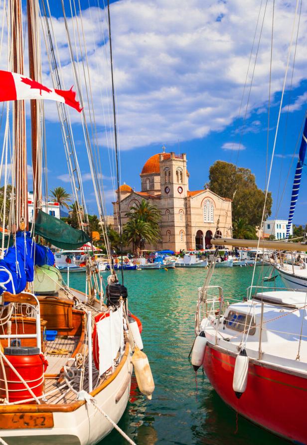 Boote liegen in einem Hafen mit einer Kirche im Hintergrund.