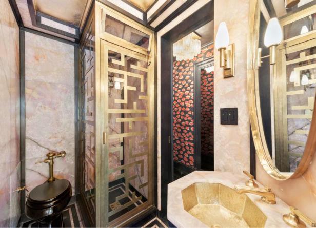 Ein luxuriöses Badezimmer mit goldenen Akzenten und gemusterten Wänden.