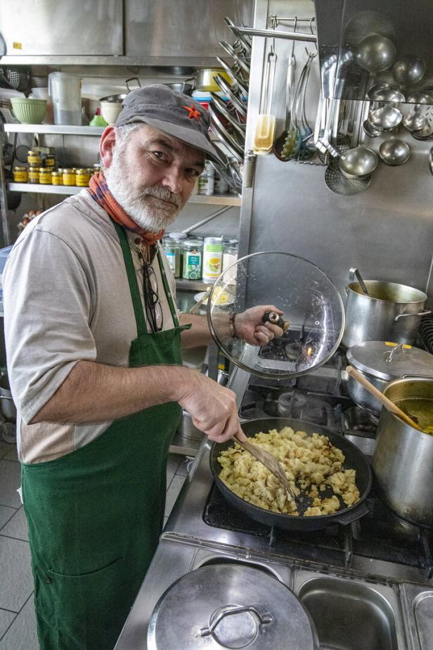 Koch im Schiestlhaus in der Küche, rührt in einer Pfanne