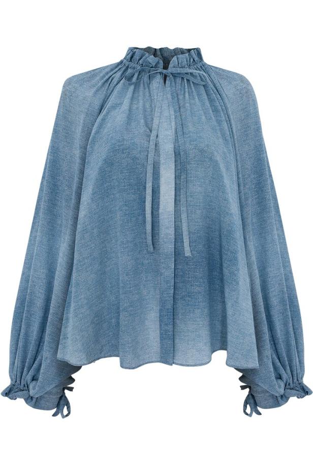 Eine blaue Bluse mit Rüschenkragen und langen, gerafften Ärmeln.