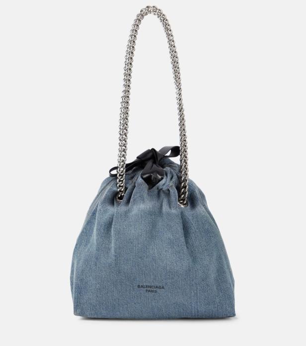 Eine blaue Balenciaga Handtasche aus Denim mit silberner Kette und schwarzer Schleife.