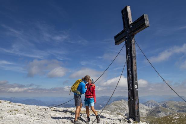 Paar küsst sich vorm Gipfelkreuz des Hochschwabs