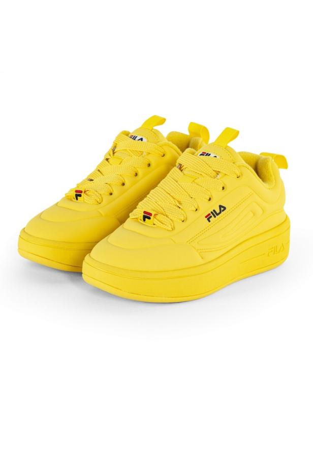 Ein Paar gelbe Fila-Sneakers stehen auf einem weißen Hintergrund.