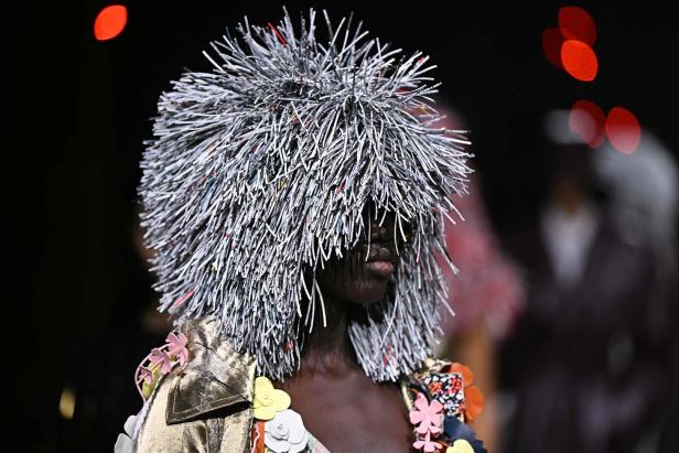 Ein Model mit einem extravaganten Kopfschmuck aus Papierstreifen auf der Mailänder Modewoche.