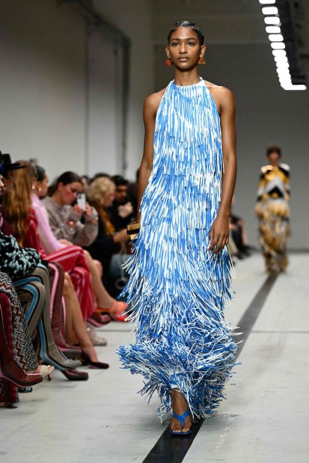 Ein Model präsentiert ein blau-weißes Fransenkleid auf dem Laufsteg der Mailänder Modewoche.
