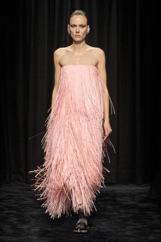 Ein Model präsentiert ein trägerloses, rosa Kleid mit Fransen von Jil Sander (Herbst/Winter 2025).