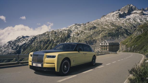 Ein gelber Rolls-Royce fährt auf einer Bergstraße.