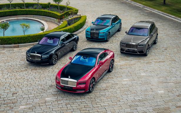 Vier Rolls-Royce-Modelle (Ghost, Phantom, Spectre, Cullinan) stehen auf einem gepflasterten Platz.