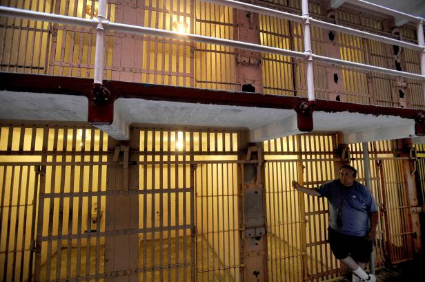 FILE PHOTO: A visitor to Alcatraz Island's former federal prison leans against a B Block cell in the San Francisco Bay