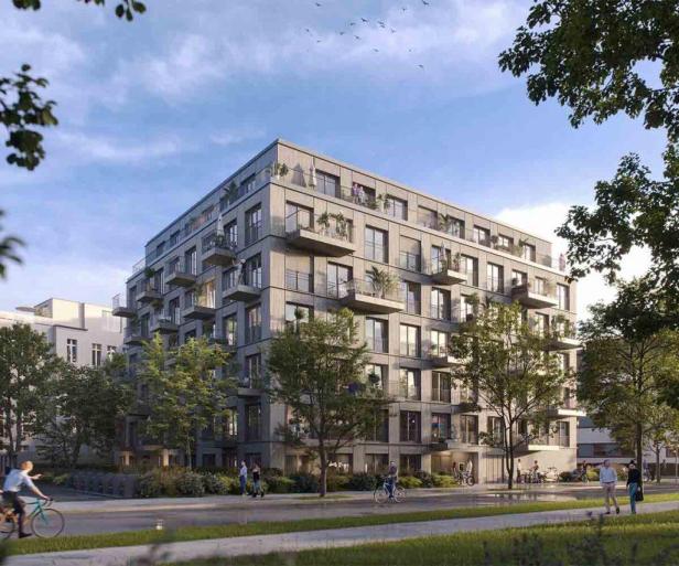 Ein modernes Mehrfamilienhaus mit vielen Balkonen und Bäumen davor.