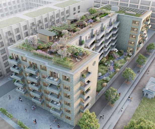 Ein Mehrfamilienhaus mit begrünten Dächern und Balkonen in einer städtischen Umgebung.
