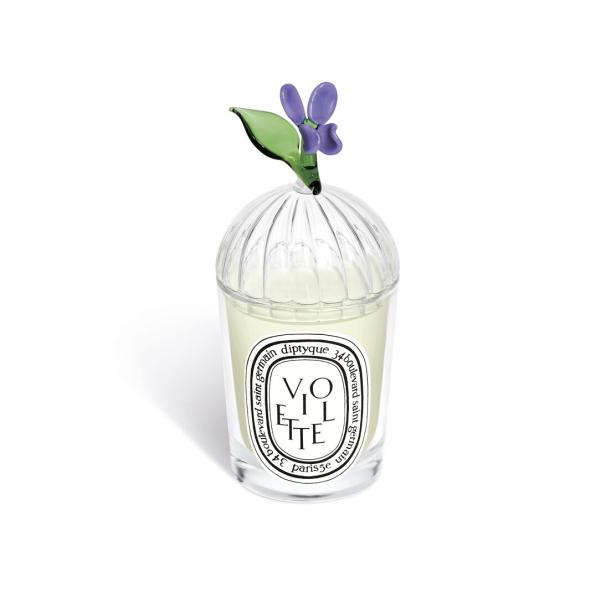 Eine „Diptyque“ Duftkerze „Violette“ mit einem Glasaufsatz in Form eines Veilchens.