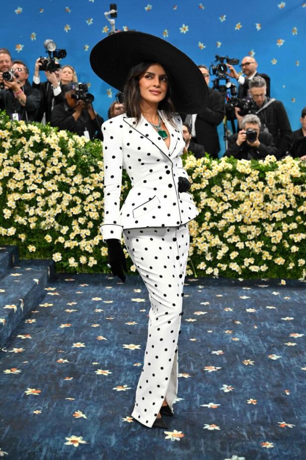 Priyanka Chopra in einem gepunkteten Anzug und einem großen Hut auf dem roten Teppich der Met Gala.